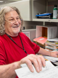 Goodwill Business Service employee, male, glasses, red shirt