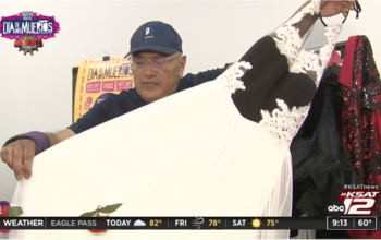 Fashion Designer and Goodwill San Antonio Community Engagement Manager Agosto Cuellar holds up a black and white gown found at a Goodwill store. The gown will be used at a dia de los muertos fashion show during San Antonio's Muerto Fest.