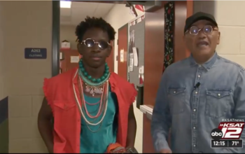 A student from Stevens High School in San Antonio Texas models his Goodwill fashion outfit for the Stevens High School and Goodwill San Antonio Fiesta Fashion Show. Agosto Cuellar stands beside the student providing an interview for KSAT 12.