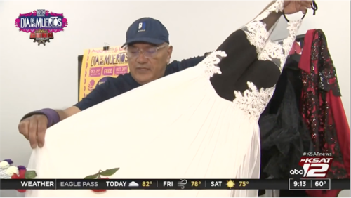 Fashion Designer and Goodwill San Antonio Community Engagement Manager Agosto Cuellar holds up a black and white gown found at a Goodwill store. The gown will be used at a dia de los muertos fashion show during San Antonio's Muerto Fest.