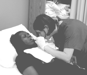 Nurse's Aide Brushing Patient's Teeth